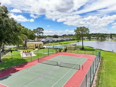 a tennis court in front of a lake at Magical Dreams home in Kissimmee