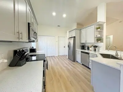 a kitchen with white cabinets and stainless steel appliances at Magical Dreams home in Kissimmee