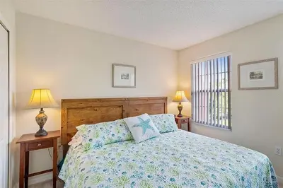 a bedroom with a bed and two lamps and a window at Ormond Retreat townhouse in Kissimmee