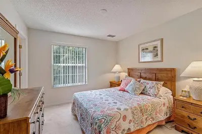 a bedroom with a bed and a dresser and a window at Ormond Retreat townhouse in Kissimmee