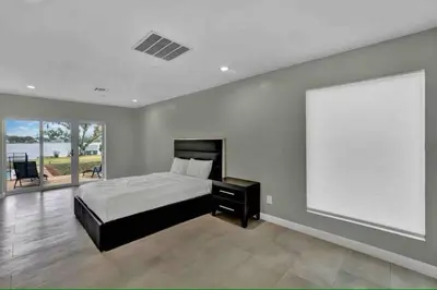 a bedroom with a bed and a large window at Casa 5Q c/ Piscina e Vista Lago — 3min Universal in Orlando