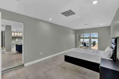 a bedroom with a bed and a living room at Casa 5Q c/ Piscina e Vista Lago — 3min Universal in Orlando