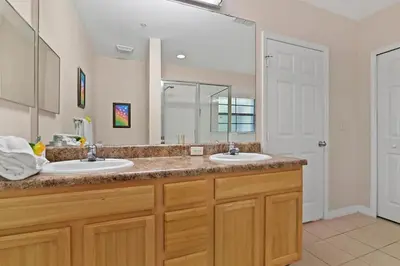 a bathroom with two sinks and a large mirror at Serene Gem, close to Disney- HEATEDsaltwaterPOOL in Kissimmee