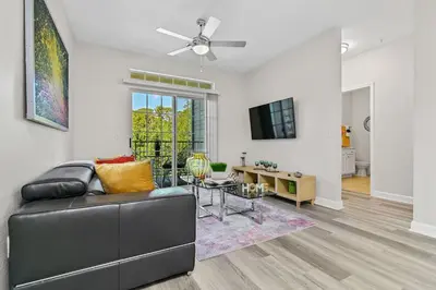 a living room with a couch and a table at Stylish 3BR Condo Near Disney Pool, Gym & More! in Kissimmee