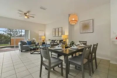 a dining room and living room with a table and chairs at Adventure Awaits! Pool Home just 10 Min to Disney! in Kissimmee