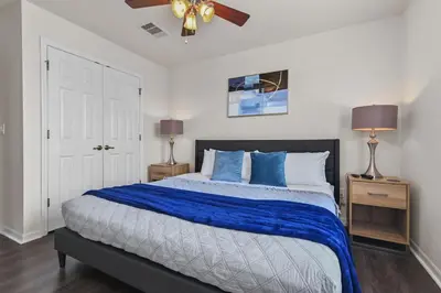 a bedroom with a large bed with blue pillows at Adventure Awaits! Pool Home just 10 Min to Disney! in Kissimmee