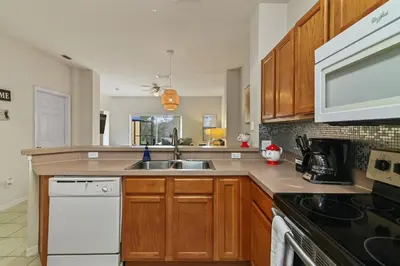 a kitchen with wooden cabinets and a sink at Adventure Awaits! Pool Home just 10 Min to Disney! in Kissimmee