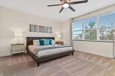 a bedroom with a bed and a ceiling fan at Unplug in your private oasis-NEW corner Home Pool in Orlando