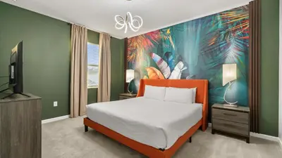 a bedroom with a bed and a tv and a painting at Upstay Bella Vida Retreat w Pool Cinema and Games in Kissimmee