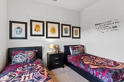 a bedroom with two beds and pictures on the wall at Casa 4Q West Lucaya – 5min da Disney in Kissimmee