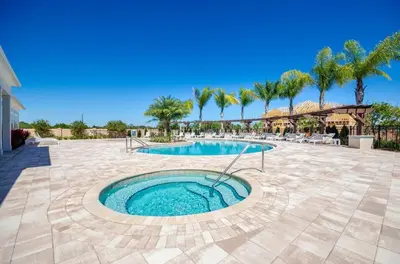 a swimming pool in a patio with palm trees at Casa 4Q West Lucaya – 5min da Disney in Kissimmee