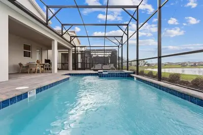 a swimming pool with a view of a house at Casa 7Q Storey Lake c/ Piscina, Spa e Game Room in Kissimmee