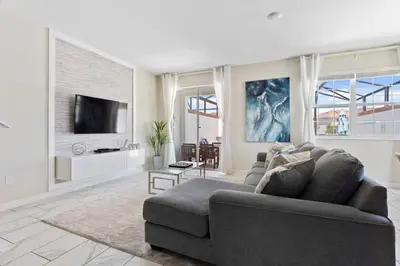 a living room with a couch and a tv at Casa 5Q c/ Piscina Privativa - Storey Lake Resort in Kissimmee