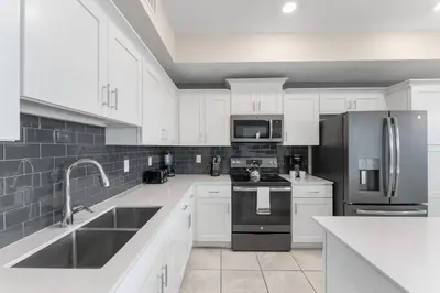 a kitchen with white cabinets and stainless steel appliances at 3121-207 Resort Lake View Disney Universal Orlando in Kissimmee