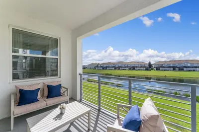 a balcony with a couch and a table and a window at 3121-207 Resort Lake View Disney Universal Orlando in Kissimmee