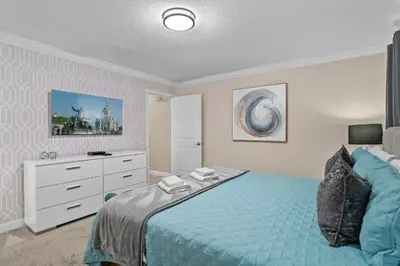 a bedroom with a blue bed and a dresser at Villa 4Q c/ Piscina Priv. & Temática in Kissimmee