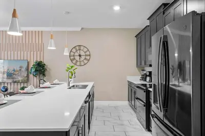 a kitchen with black cabinets and a refrigerator at Villa 4Q c/ Piscina Priv. & Temática in Kissimmee
