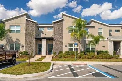 a large apartment building with a parking lot at Villa 4Q c/ Piscina Priv. & Temática in Kissimmee