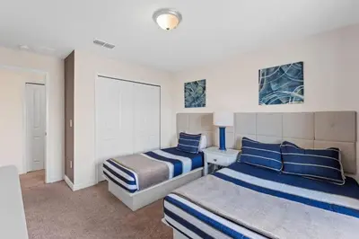 a bedroom with two beds with blue and white stripes at Casa 4Q c/ Piscina Priv. no Storey Lake in Kissimmee
