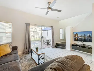 a living room with a couch and a tv at Cozy Townhouse with Private Pool in Kissimmee in Kissimmee