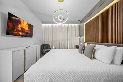 a bedroom with a bed and a tv on the wall at Brand NEW 5 BRD At Paradiso Grande Near Sea World in Orlando