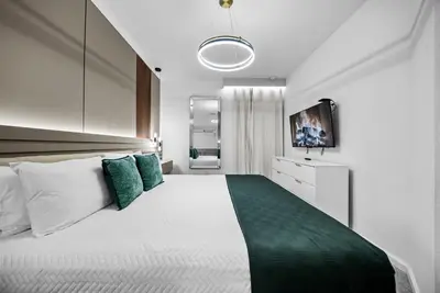 a bedroom with a large white bed with green pillows at Brand NEW 5 BRD At Paradiso Grande Near Sea World in Orlando
