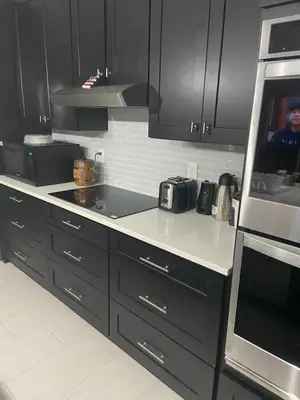 a kitchen with black cabinets and white counter tops at Orlando 4 bedroom built in 2021 in Orlando
