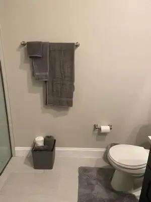 a bathroom with a toilet and towels on the wall at Orlando 4 bedroom built in 2021 in Orlando