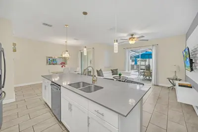 a kitchen with a sink and a living room at Beautiful Paradise Palms Retreat townhouse in Kissimmee