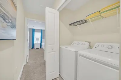 a white laundry room with a washer and dryer at Beautiful Paradise Palms Retreat townhouse in Kissimmee