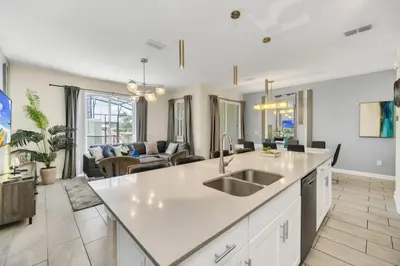 a kitchen and living room with a sink and a couch at Retreat & Relax Screened In Pool Home Kid Rooms townhouse in Kissimmee