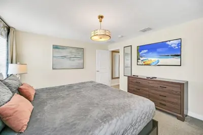 a bedroom with a large bed and a dresser at Retreat & Relax Screened In Pool Home Kid Rooms townhouse in Kissimmee