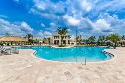 a swimming pool at a resort with palm trees at Retreat & Relax Screened In Pool Home Kid Rooms townhouse in Kissimmee