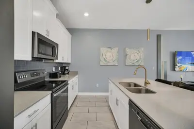 a kitchen with a sink and a stove top oven at Retreat & Relax Screened In Pool Home Kid Rooms townhouse in Kissimmee