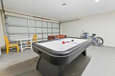 a room with a ping pong table and a bike at Casa 5Q c/ Piscina Priv. e Sala de Jogos in Kissimmee