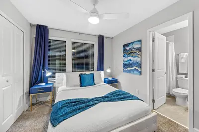 a bedroom with a bed and a toilet and blue curtains at Gated community 4BD townhouse next to Disney in Kissimmee