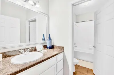 a bathroom with a sink and a toilet and a mirror at Upstay Pet-Friendly Condo with Pool in Orlando
