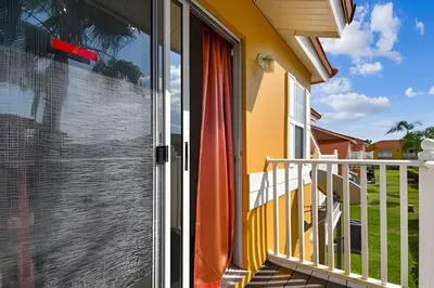 a sliding glass door on a balcony of a house at Casa Aconchegante no Lake Berkley – Perto da Disney in Kissimmee