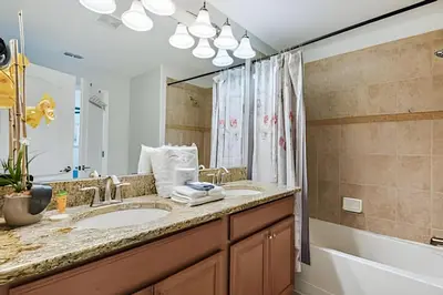 a bathroom with two sinks and a tub and a large mirror at Casa Familiar c Piscina Privativa Paradise Palms in Kissimmee