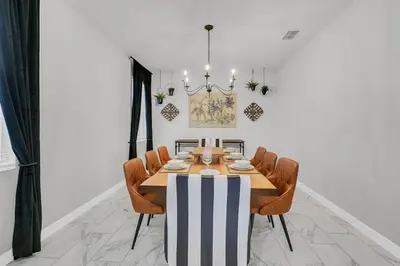 a dining room with a table and chairs at 6 Bedrooms 6 Bathrooms Storey Lake home in Orlando