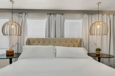 a bedroom with a large white bed with two tables at 6 Bedrooms 6 Bathrooms Storey Lake home in Orlando