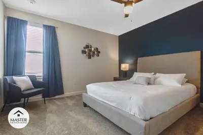 a bedroom with a large bed and a chair at 9 Bedrooms 5 Bathrooms Storey Lake home in Kissimmee