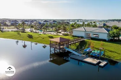 an aerial view of a house with a dock on the water at 9 Bedrooms 5 Bathrooms Storey Lake home in Kissimmee