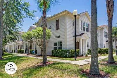 a house with palm trees in front of it at 4 Bedroom 3 Bathroom Lucaya Village townhouse in Kissimmee
