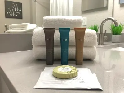 a bathroom counter with three bottles ofodorizers and towels at 3 Bedrooms 2 Bathrooms Lucaya Village townhouse in Kissimmee