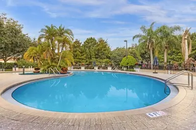 a swimming pool in a park with palm trees at 3 Bedrooms 2 Bathrooms Lucaya Village townhouse in Kissimmee