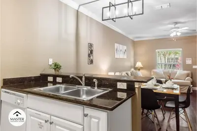 a kitchen with a sink and a living room at 3 Bedrooms 2 Bathrooms Lucaya Village townhouse in Kissimmee