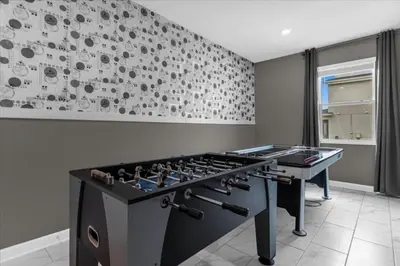 a ping pong table in a room with a wall at 7 Bedroom 6 Bathrooms Storey Lake Resort home in Kissimmee