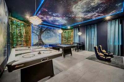 a game room with a table and a tree mural at 9 bedrooms 5 Bathrooms Storey Lake Game Room Too home in Kissimmee