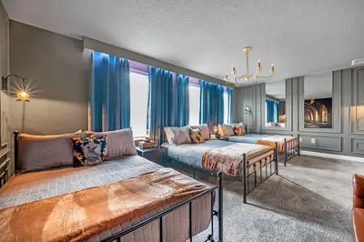 a large bedroom with two beds and a couch at 9 bedrooms 5 Bathrooms Storey Lake Game Room Too home in Kissimmee